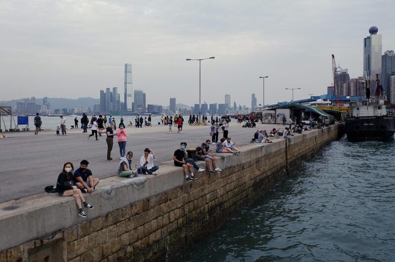 In this picture taken on April 13, 2020, people visit a public cargo loading area dubbed 'Instagram Pier' in Hong Kong. Starting on March 29 the city's government banned public gatherings of more than four people in an effort to curb the spread of the COVID-19 coronavirus. / AFP / Daniel SUEN
