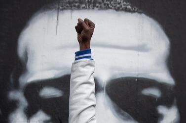 Local resident Michael Wilson raises his fist in front of an image of George Floyd after the verdict in the trial of former Minneapolis police officer Derek Chauvin. Reuters