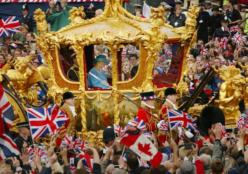 Queen Elizabeth and Prince Philip ride in the Golden State Carriage at the head of a parade from Buckingham Palace to St Paul's Cathedral celebrating her golden jubilee in June 2002.