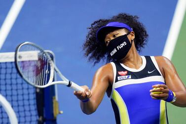 Naomi Osaka, wearing a face mask emblazoned with the name George Floyd, hits balls into the stands after her US Open quarter-final win over Shelby Rogers. AP Photo