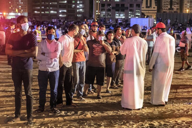 SHARJAH, UNITED ARAB EMIRATES. 05 MAY 2020. STANDALONE. Fire at the Abbco Tower near Nahda Park in Sharjah. Police and fire fighters responded to a blaze that was reported after 8:30. Police and Red Crecent members take the detailsof occupants while handing them water and juice. (Photo: Antonie Robertson/The National) Journalist: Salam Al Amir. Section: National.