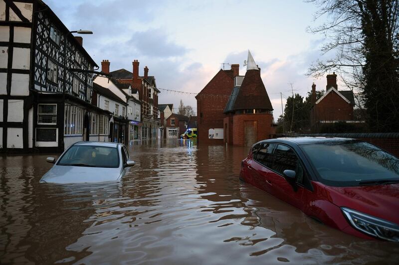 Flood water surrounds abandoned cars left in a flooded street in Tenbury Wells, after the River Teme burst its banks in western England. AFP