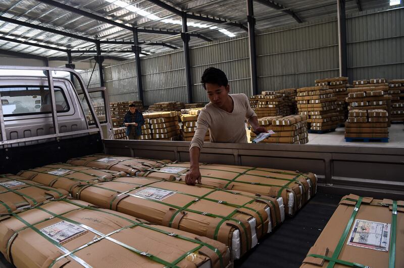 In this photograph taken on November 8, 2017, labourers work inside a furniture factory in a "Taobao Village" in Xuzhou. 
Workers wielding screeching hand-held wood sanders toil overtime in Cheng Huaibao's bunk bed factory, rushing to prepare for the wave of orders about to break on manufacturing businesses like his across China. China's November 11 orgy of e-shopping strikes Saturday, with hundreds of millions of consumers expected to seize on promotional discounts to place up to a billion pent-up orders for everything from food to furniture and electronics. / AFP PHOTO / Chandan KHANNA / TO GO WITH China-Alibaba-retail-e-commerce-manufacturing, FOCUS by Albee ZHANG