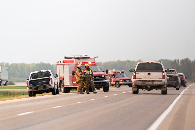 Firefighters gather at the scene where stabbing suspect Myles Sanderson was arrested in Rosthern, Saskatchewan. AP