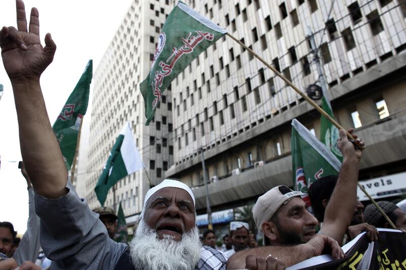 Demonstrators wave flags during an anti-India protest in Karachi, Pakistan. Bloomberg