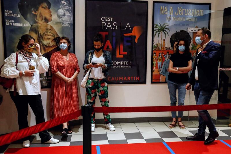 Customers wait in the lobby of Cinema 5 Caumartin in Paris ahead of its opening just after midnight, after cinemas in France were allowed to reopen on June 22. AFP