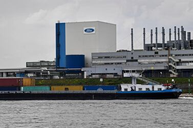 A container ship passes the Ford car plant in Cologne. AP