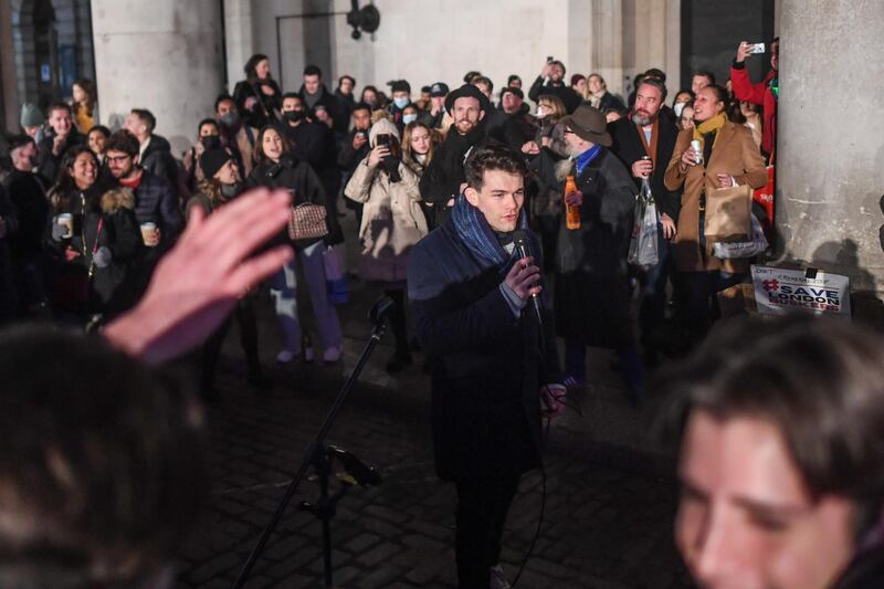 LONDON, ENGLAND  - DECEMBER 05:  Crowds of people listen to a busker in Covent Garden on December 5, 2020 in London, England. On Tuesday night, Dec 1, MPs voted in favour of government proposals to enter England into a tiered system of lockdown beginning at midnight. Residents of Tier Two - High Alert can socialise with anyone they live with or who is in their support bubble in any indoor setting, whether at home or in a public place. Outdoors they must observe the rule of six. Pubs and bars must close, unless operating as restaurants. Hospitality venues can only serve alcohol with substantial meals and must close between 11pm and 5am with last orders called at 10pm. Organised indoor sport, physical activity and exercise classes will be permitted if it is possible for people to avoid mixing with people they do not live with. Schools remain open. (Photo by Peter Summers/Getty Images)