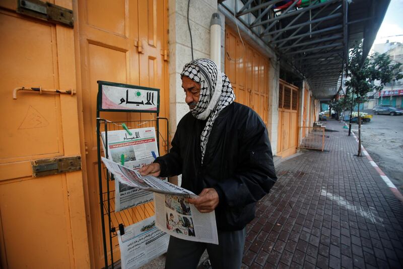 A Palestinian man in Hebron reads a newspaper during a general strike over US President Donald Trump's decision to recognise Jerusalem as the capital of Israel. Mussa Qawasma / Reuters