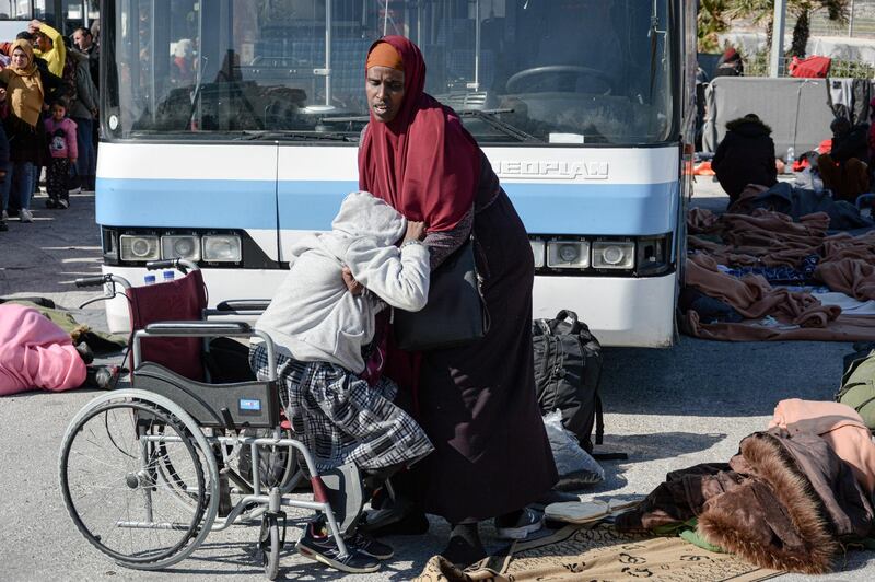 An elderly migrant woman is helped out of a wheelchair at the port of Mytilene on the northeastern Aegean island of Lesbos, Greece. AP Photo