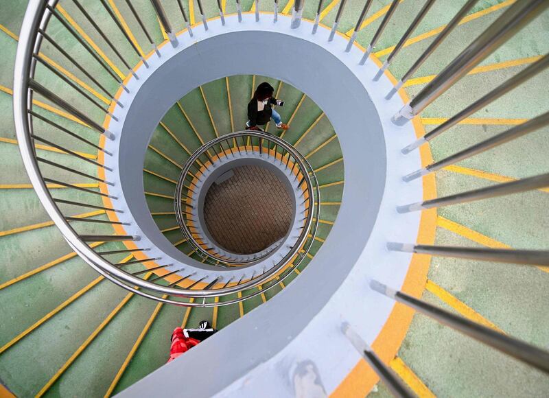 A pedestrian walks up a staircase of an overpass in Beijing, China. AFP