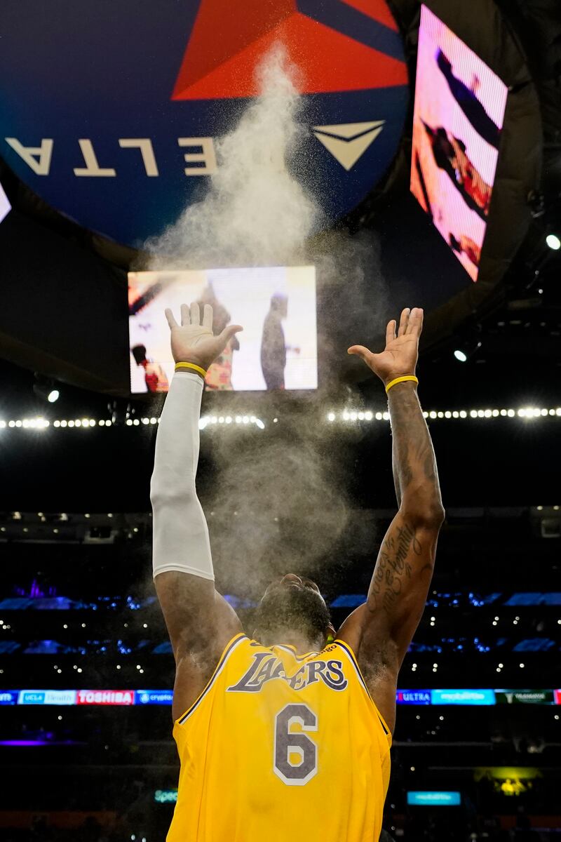 LeBron James goes through his routine of throwing powdered chalk in the air before a game. AP