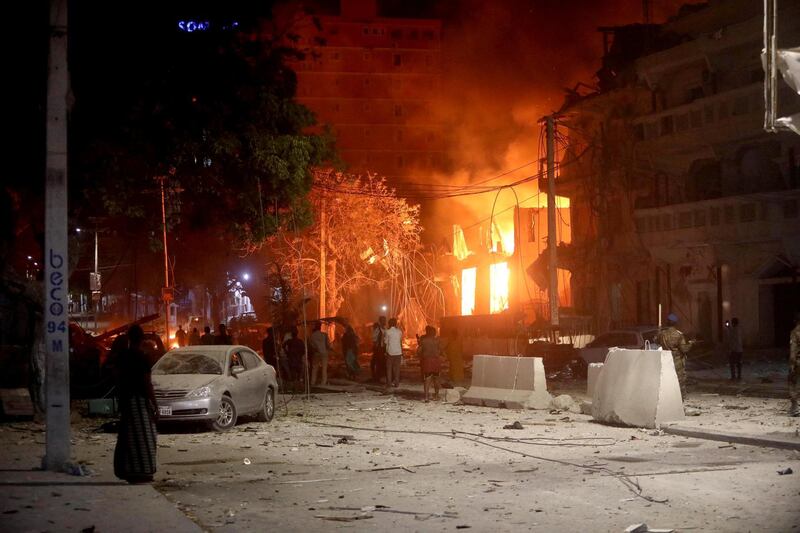 People look at flames at the scene where a suicide car bomb exploded targeting a hotel in the Somali capital. Reuters