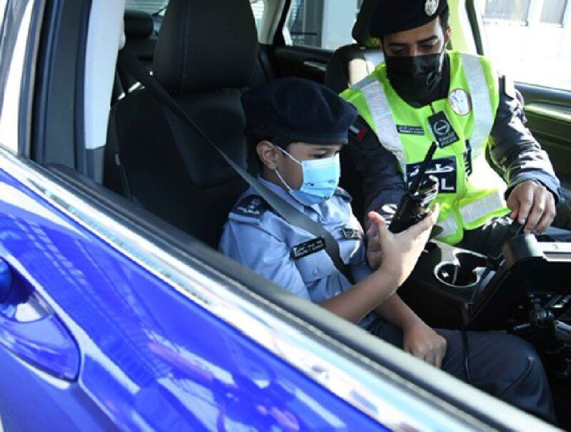 Khalifa checks out a walkie-talkie with an officer from Al Rawdah police station in the capital.