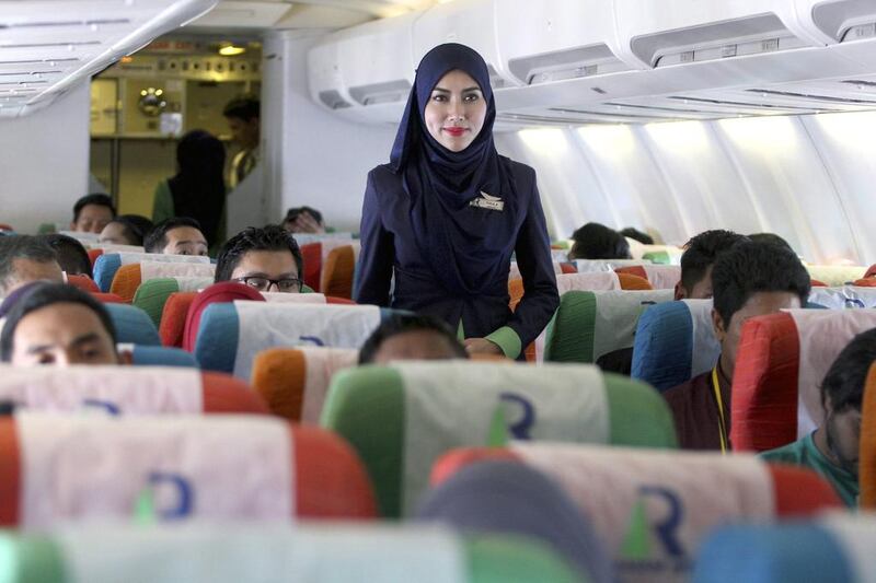 A Rayani Air flight attendant assists passengers before take off from Kuala Lumpur to Langkawi, in Sepang, Malaysia. EPA