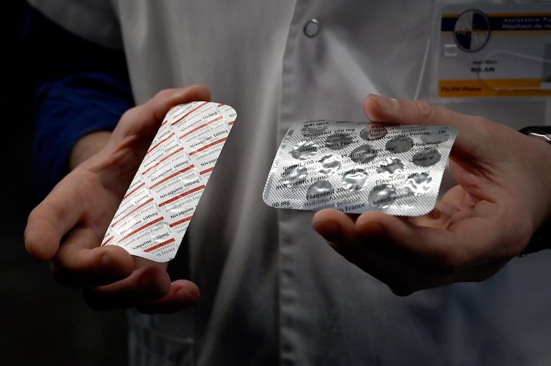 (FILES) In this file photo taken on February 26, 2020 a medical staff shows at the IHU Mediterranee Infection Institute in Marseille, packets of a Nivaquine, tablets containing chloroquine and Plaqueril, tablets containing hydroxychloroquine, drugs that has shown signs of effectiveness against coronavirus.   / AFP / GERARD JULIEN
