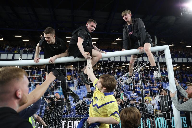  Everton fans climb on the goal during a pitch invasion after the match to celebrate avoiding relegation. Action Images