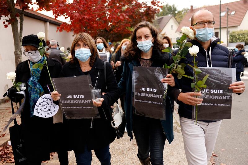 Teachers carrying a sign that reads 'I am a Teacher' lays flowers in front of Bois d'Aulne middle school to pay their respect after a teacher was assassinated in Conflans Sainte-Honorine. EPA