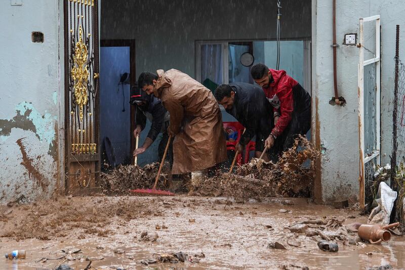 Iraqi men take part in a clean-up operation after heavy rains in Dohuk, in Iraq's Kurdish region. AFP