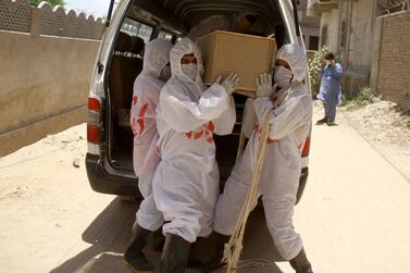 Workers prepare the burial of a victim who died of coronavirus in Hyderabad, Pakistan. EPA