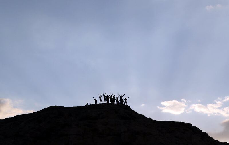 Explorers cheer from the top of a hill after cutting a new trail in Wadi Billi, Egypt. Reuters