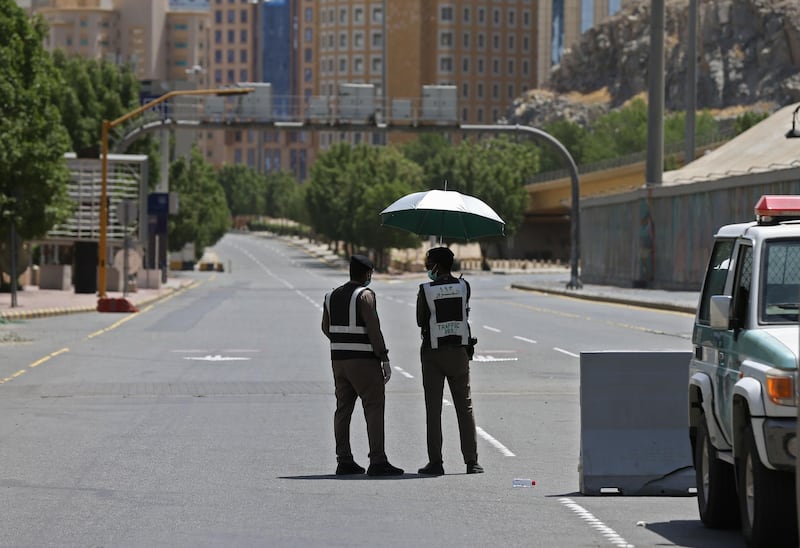 Police officers man a checkpoint in a street in Saudi Arabia's holy city of Makkah on April 3, 2020. AFP