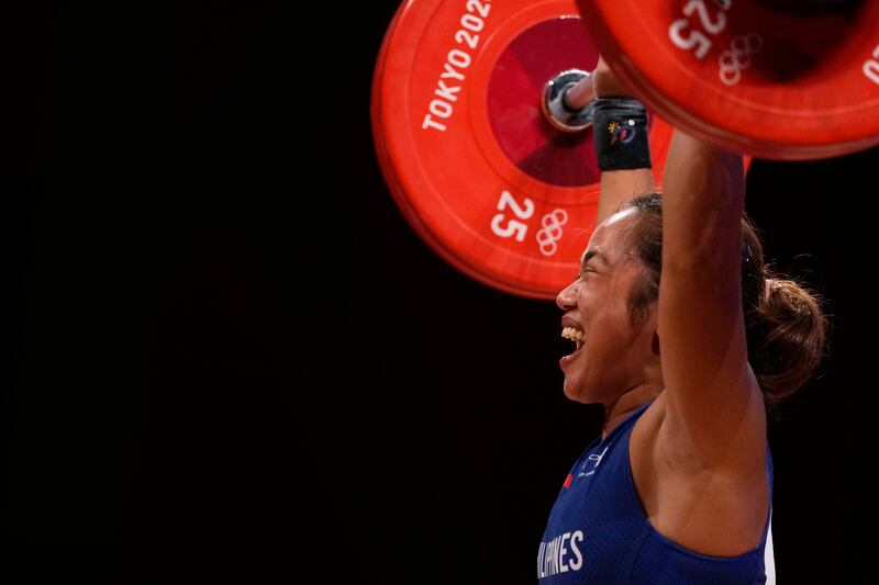 Hidilyn Diaz of Philippines celebrates as she competes and sets new world record and won the gold medal in the women's 55kg weightlifting event.