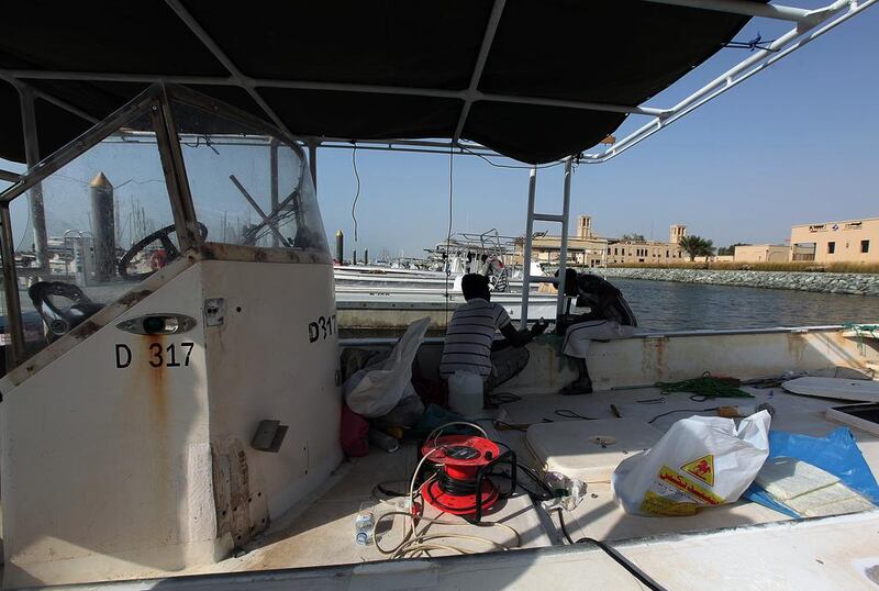 Fishermen maintaining their boat at the fishing harbour in Dubai. Satish Kumar / The National