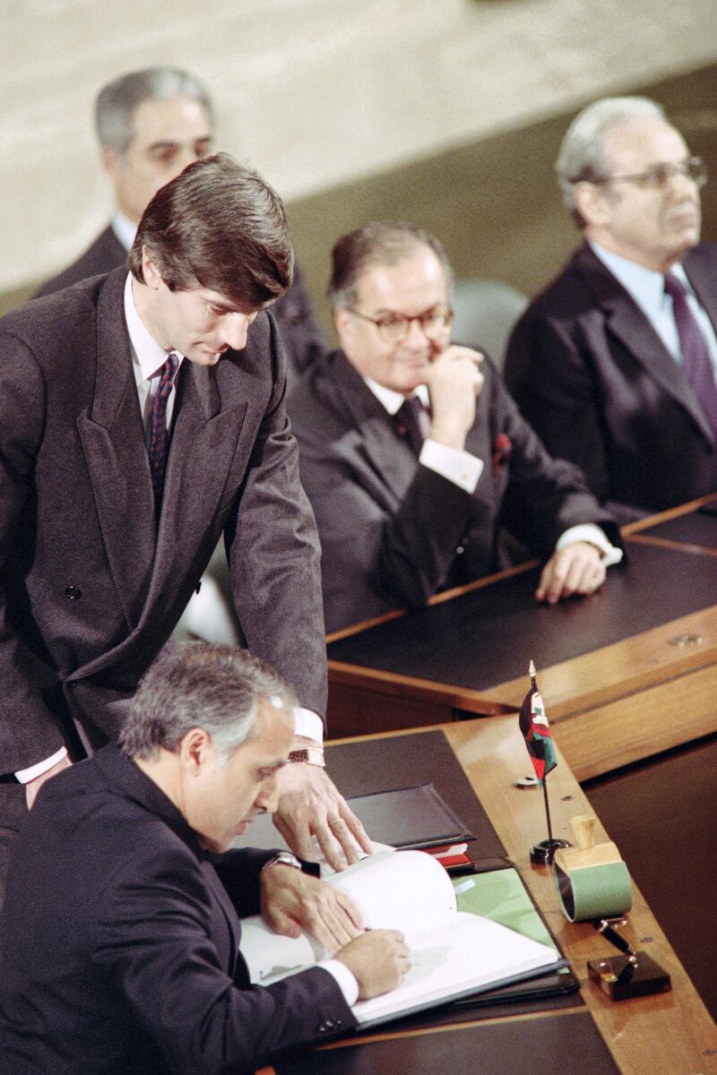 Afghan Foreign Minister Mohammad Abdul Wakil signs the Geneva Accords of agreement on the withdrawal of Soviet troops from Afghanistan on April 14, 1988 in Geneva as U.N. General Secretary for Foreign Affairs Diego Cordovez (C) and U.N. Secretary General Javier Perez de Cuellar(R)look on. (Photo by Gerard MALIE / AFP)