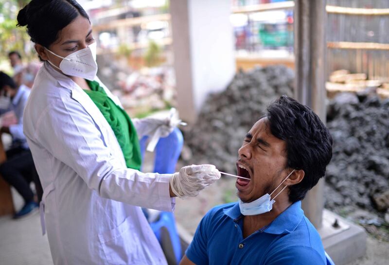 A Bangladeshi health worker takes a mouth swab to test for Covid-19 in Dhaka, Bangladesh. On Saturday, officials detected an Indian variant for the first time. AP Photo