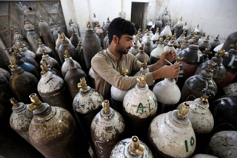 A man fills oxygen cylinders as the number of Covid-19 patients in Peshawar, Pakistan, rises. EPA