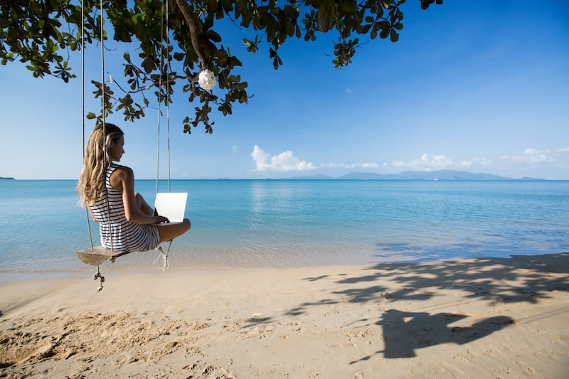 Armed with laptops and flexible visas, an increasing number of workers are logging in from the beach. Getty Images