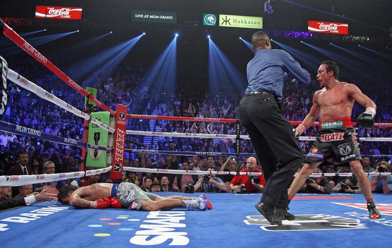 Referee Kenny Bayless (C) holds back Juan Manuel Marquez (R) as Manny Pacquiao (L) lies face down on the mat after being knocked out by Juan Manuel Marquez on December 8, 2012, at the MGM Grand Garden in Las Vegas, Nevada.  AFP PHOTO / John Gurzinski
 *** Local Caption ***  064496-01-08.jpg