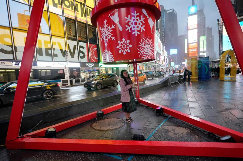 Priscilla Batz takes shelter from the rain beneath a giant Salvation Army collection kettle on Christmas Eve in New York. AP Photo