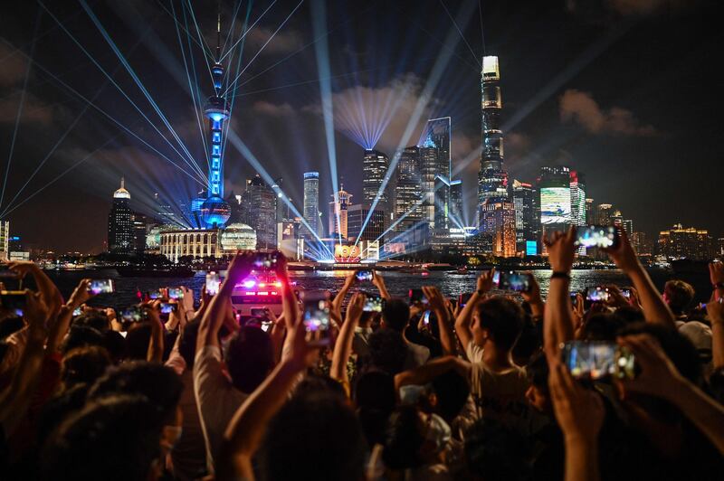 People watch a light show on the Bund promenade in Shanghai, on the eve of the 100th anniversary of the Chinese Communist Party's establishment.