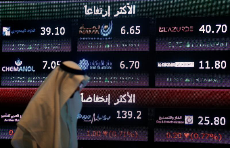 An investor walks past a screen displaying stock information at the Saudi Stock Exchange (Tadawul). Reuters