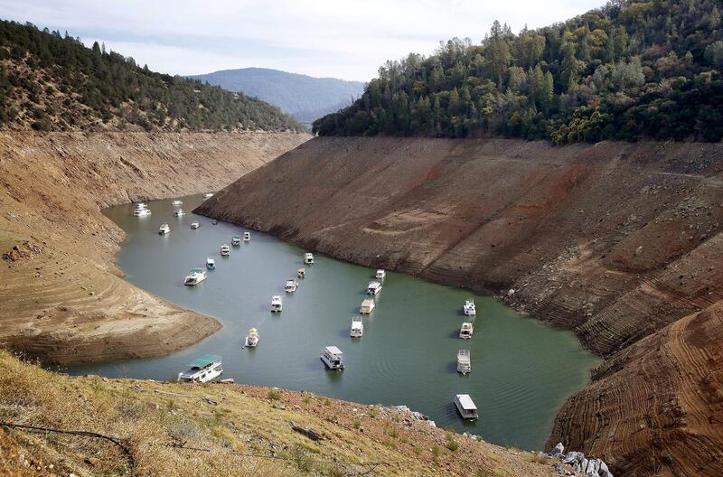 FILE - In this Oct. 30, 2014, file photo, houseboats float in the drought-lowered waters of Oroville Lake near Oroville, Calif. Rainstorms grew more erratic and droughts much longer across most of the U.S. West over the past half-century as climate change warmed the planet, according to a sweeping government study released, Tuesday, April 6, 2021, that concludes the situation in the region is worsening.(AP Photo/Rich Pedroncelli, File)