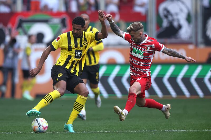 Sebastien Haller of Borussia Dortmund is challenged by Niklas Dorsch of Augsburg. Getty Images