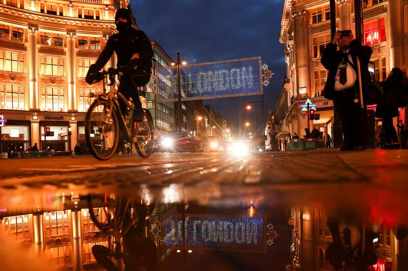 A cyclist rides past the Christmas lights on Oxford Street. Reuters
