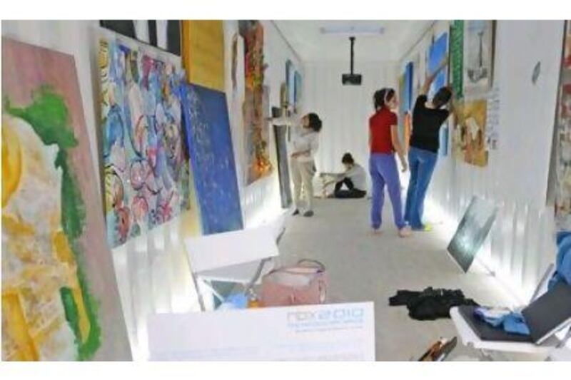 Young female entrepreneur artists prepare for a display of their artwork at Nomads Box in Dubai.