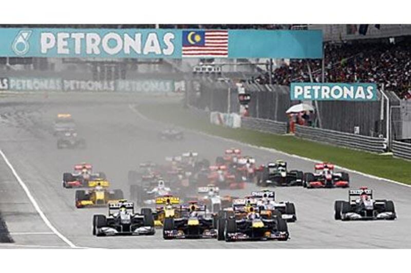 Mark Webber, front right, moves up behind Red Bull teammate Sebastian Vettel, front left, at the start the Malaysian Grand Prix.