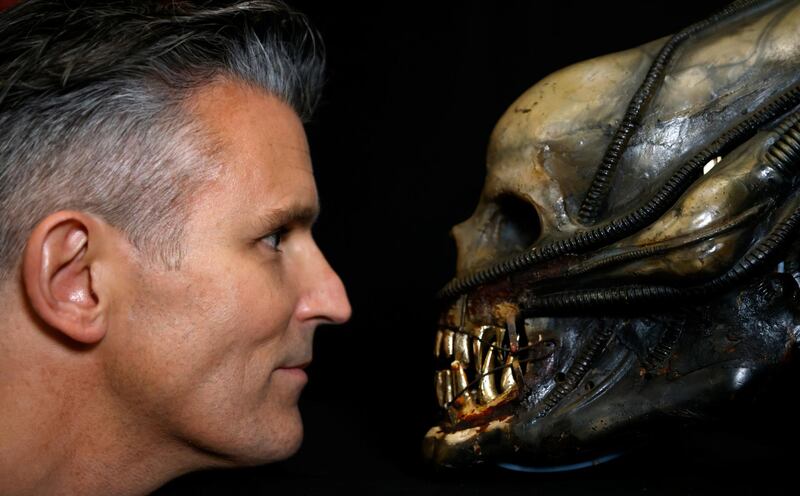 Stephen Lane, chief executive of Prop Store, poses for a photograph with a special effects mechanical head from the film 'Alien' at a preview of a movie and TV memorabilia auction. Reuters