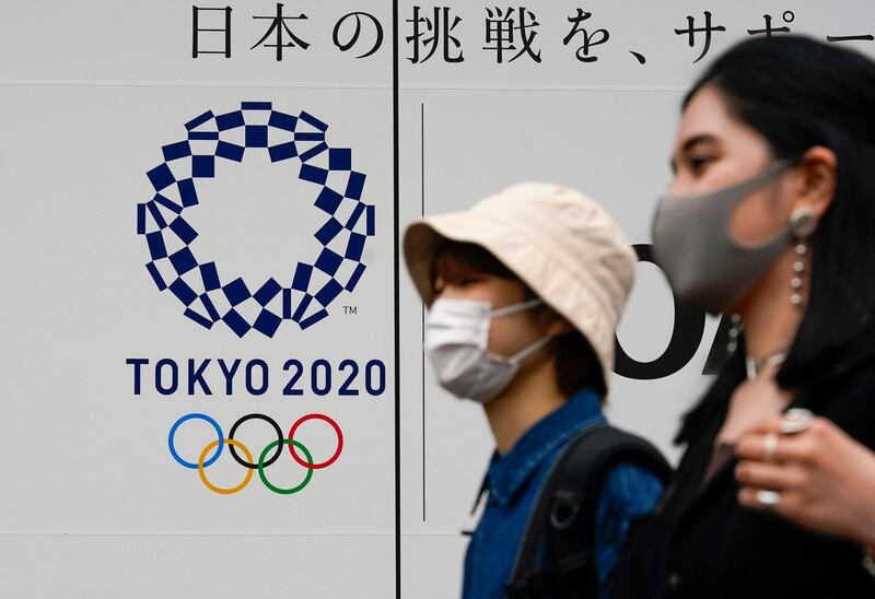 epa09211586 Pedestrians walk past the logo of Tokyo 2020 Olympic Games in Tokyo, Japan, 19 May 2021, as a three-day meeting of the IOC Coordination Commission for the Games of the XXXII Olympiad starts.  The International Olympic Committee, the Tokyo 2020 Organising Committee, the Tokyo Metropolitan Government, the Japanese Olympic Committee, the Government of Japan and other relevant parties participate in the meeting.  EPA/KIMIMASA MAYAMA
