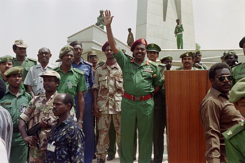 Picture taken on July 11, 1989 at Khartoum showing Sudanese military and political leader Omar al-Bashir waving his supporters during a rally. (Photo by Mike NELSON / AFP)