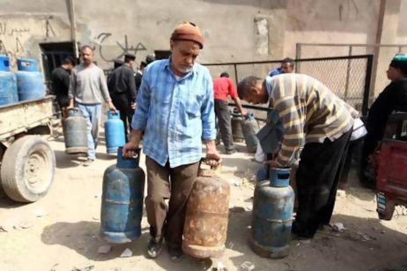A man carries cooking gas cylinders at a selling depot in Cairo. There are no plans for reforming subsidies of fuel and food, which account for about 10 per cent of GDP.