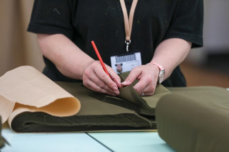 A worker handles material to be made into protective gowns for workers in the U.K. National Health Service (NHS) at the Burberry Group Plc factory in Castleford, U.K., on Tuesday, April 21, 2020. The U.K. ran the risks running out of protective equipment for its hospital staff as half the doctors working in high-risk areas reported supply shortages in an April survey by the British Medical Association. Photographer: Chris Ratcliffe/Bloomberg