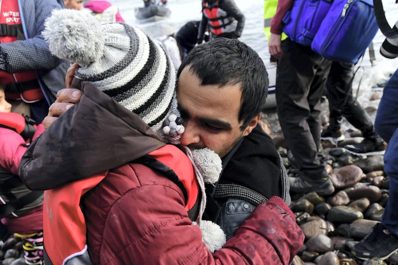 A man hugs a child upon their arrival at the village of Skala Sikaminias, on the Greek island of Lesbos, after crossing the Aegean sea from Turkey, on Friday, Feb. 28, 2020. An air strike by Syrian government forces killed scores of Turkish soldiers in northeast Syria, a Turkish official said Friday, marking the largest death toll for Turkey in a single day since it first intervened in Syria in 2016. (AP Photo/Micheal Varaklas)