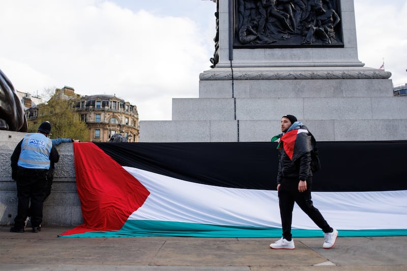 Protesters place a large  Palestinian flag in Trafalgar Square during a vigil in London. EPA