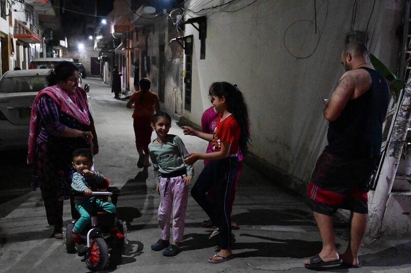 Residents gather outside their homes in Amritsar. AFP
