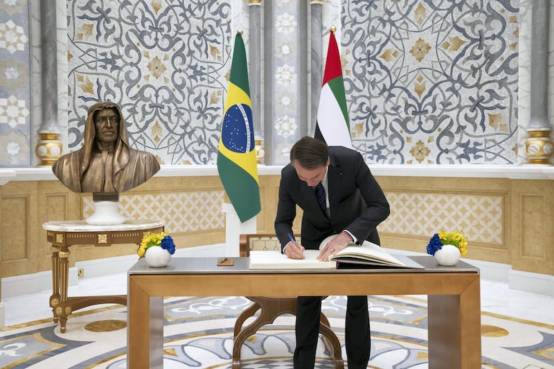 ABU DHABI, UNITED ARAB EMIRATES - October 27, 2019: HE Jair Bolsonaro, President of Brazil (C), signs the visitor book during an official reception at Qasr Al Watan.

( Mohamed Al Hammadi / Ministry of Presidential Affairs )
---